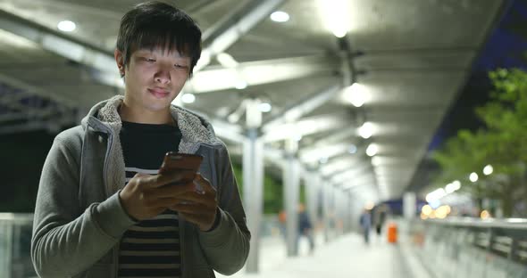 Man use of mobile phone in city at night