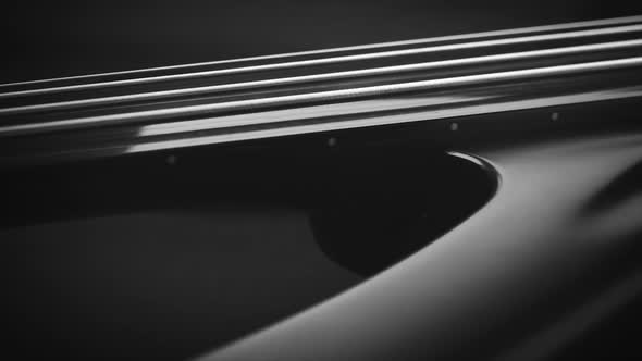 Neck and body of a fretless electric bass guitar on the dark background