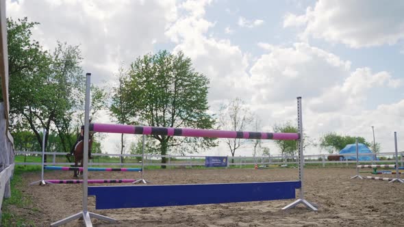 Woman Rider On A Horse Leaping Over A Fence In Sandy Parkour  Equestrian Events