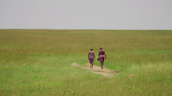 Two Maasai men walking on a path