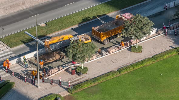 Excavator and Truck Working at Road Construction Site in Dubai Downtown Timelapse