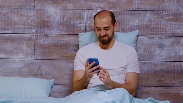 Man Using Phone and Looking at Social Media Content