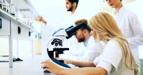 Young Scientist Looking Through Microscope in Laboratory