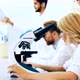 Young Scientist Looking Through Microscope in Laboratory - VideoHive Item for Sale