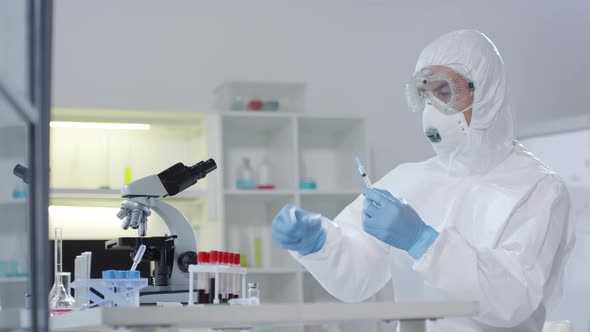 Medical Scientist Flicking Syringe in Laboratory