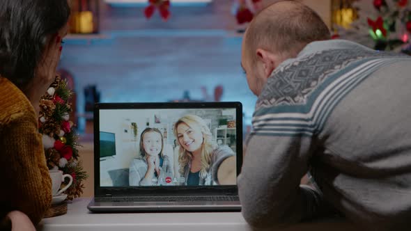 Festive Couple Talking to Family on Video Call Conference