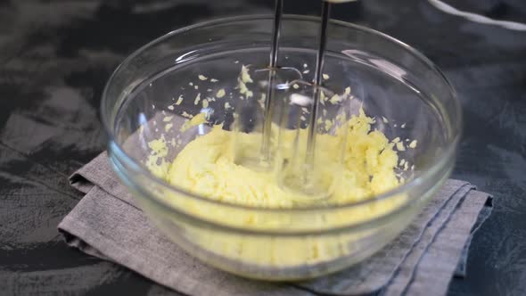 Mixing butter with sugar with the hand mixer
