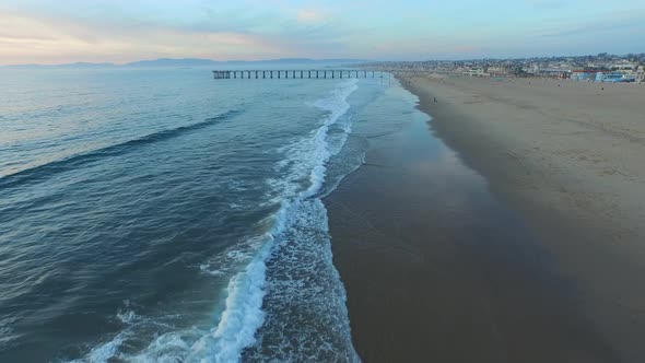 Aerial shot of a scenic beach city and ocean at sunset