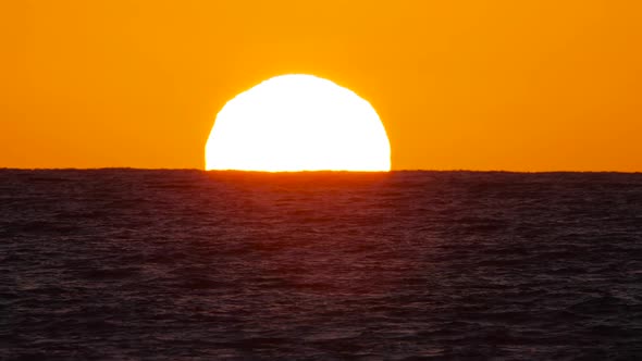 Big Red Hot Sun in Warm Air Distortion Above Ocean Horizon Sunset Over the Sea Big Rising Sun with