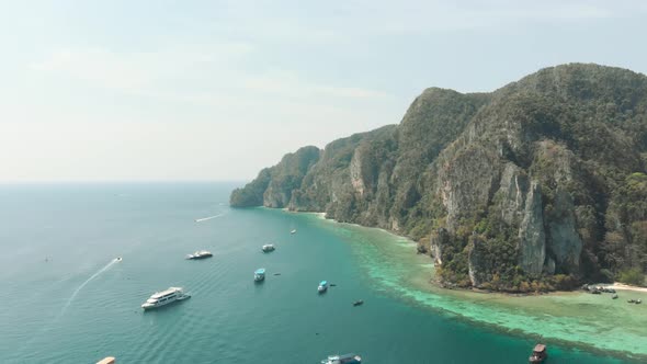 Idyllic shoreline coupled by warm exotic waters hampered by cliff near Pirate Beach Cove, Ko Phi Phi