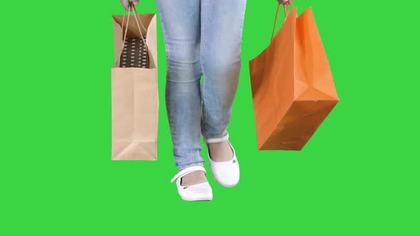Little Girl with Shopping Bags Walking on a Green Screen, Chroma Key