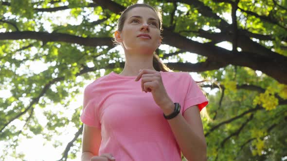 Woman Running Under Trees in Slow Motion