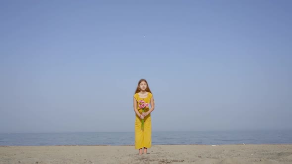 Young Girl Throws Flowers in the Air in Slow Motion on the Beach