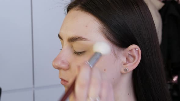 Applying a Base of Foundation Before Makeup By a Professional Makeup Artist in the Studio