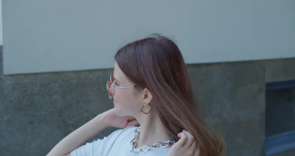 Portrait of Admiring Teen in Sunglasses Poses with Hair and Smiles at Camera