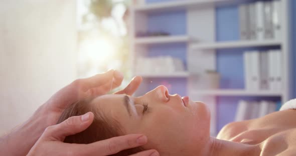 Female patient receiving head massage from physiotherapist