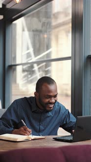 Businessman Working Remotely with Laptop at Cafe