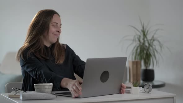 Smiling young woman freelancer using laptop computer and  typing message