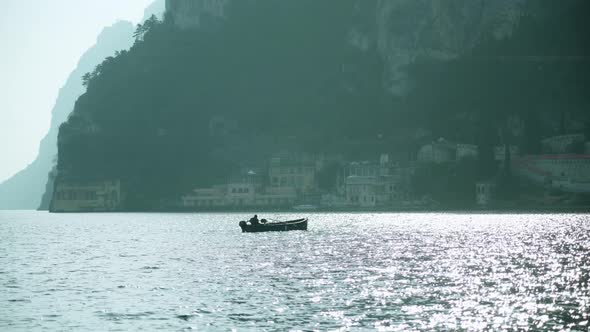 Fishing Boat Sails in Shimmering Water of Lake Garda