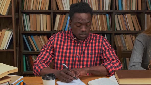 Black Guy Surrounded By Books in Library