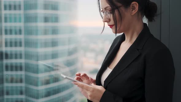 Closeup Portrait of Business Woman with a Smartphone in Her Hands. a Woman in a Business Suit Is