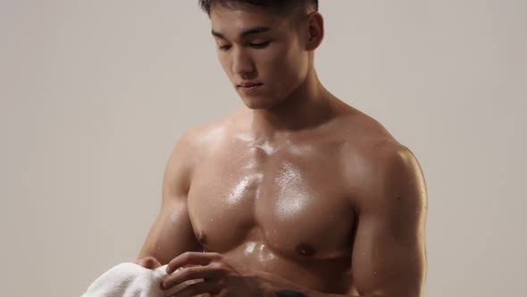 Tired Muscular Asian Man Indoors Against Gray Background