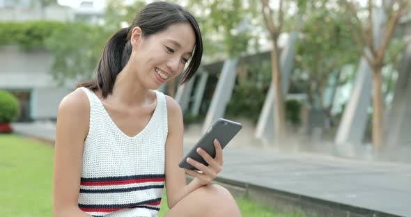 Woman looking at mobile phone in the park