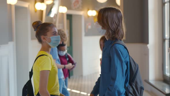 Side View of Children Wearing Safety Mask and School and Bumping Elbows Greeting Each Other