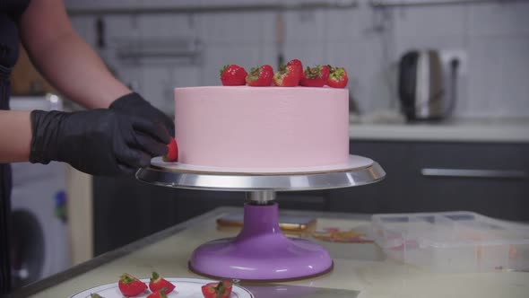 Confectionery  Pastry Chef Decorating Cake with Fresh Strawberries