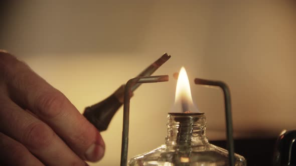 A Man Heating the Tool Using the Burner