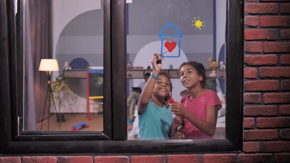 Smiling Dark-skinned Girls Painting on Window