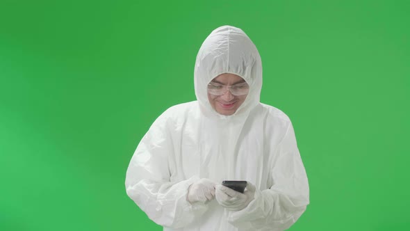 Man Wear Protective Equipment Uniform Ppe And Use Mobile Phone In The Green Screen Studio