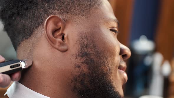 Young Africanamerican Man Visiting Barbershop for Haircut