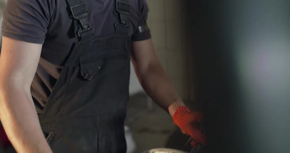 Mechanic Rotates and Lines Up an Alloy Wheel on Tyre Changer Machine