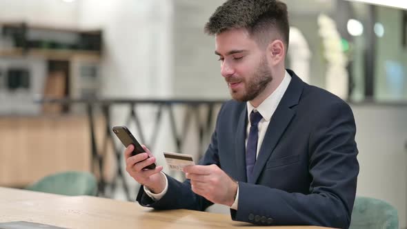 Businessman Making Successful Online Payment on Smartphone in Office