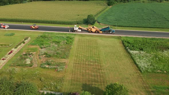 Bird view of rural highway being repaved on a beautiful summer day in the midwest.