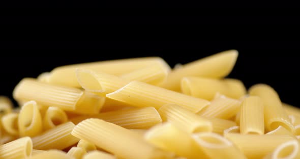 A Bunch of Dry Penne Pasta on the Table Slowly Rotates. 