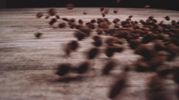 Roasted Coffee Beans Thrown Onto Wood