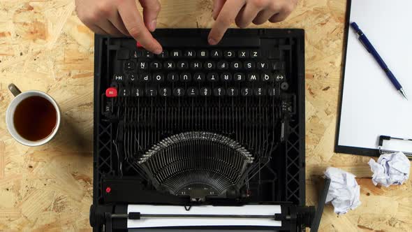 Men's Hands Type the Text of the Book on a Typewriter. View From Above