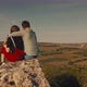 Young Couple Hugging While Sitting on A Cliff with A Beautiful View - VideoHive Item for Sale