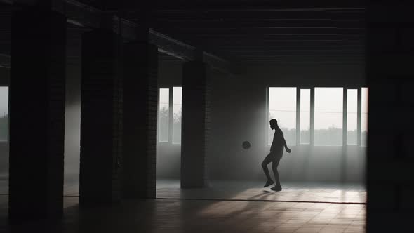 A Darkskinned Teenager Conducts a Football Training in a Ground Parking Lot