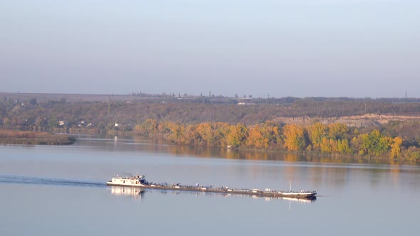 Cargo Ship Floating Along River. Colorful Trees on Shore, Landscape