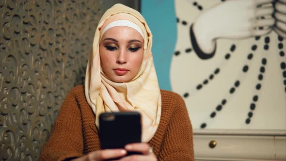 Modern Arab Woman in Hijab Communicates on Her Mobile Phone Online with Friends