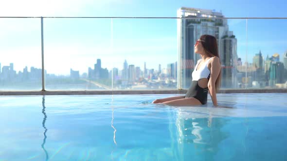 Young asian woman enjoy around outdoor swimming pool for leisure