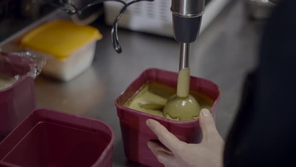Chef Uses Metal Immersion Blender to Mix Sauce in Container in Kitchen