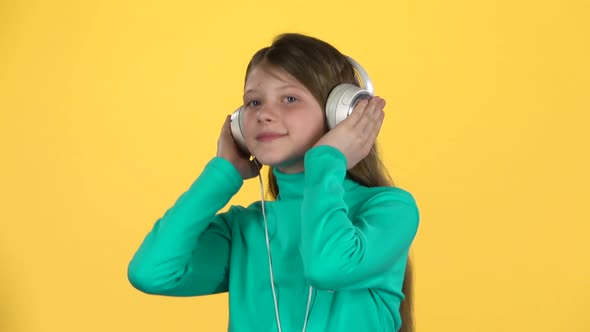 Сute Girl Listening To Music in Big White Headphones. Slow Motion