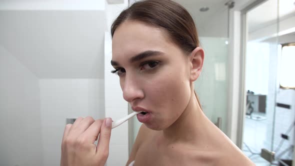 Teeth Hygiene. Woman Brushing Teeth And Looking At Camera