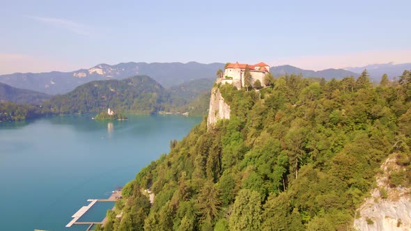 Aerial dolly in towards Bled Castle high above Bled Lake in Northern Slovenia. A top tourist destina