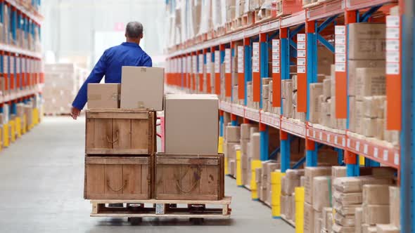 Male warehouse worker using pallet truck