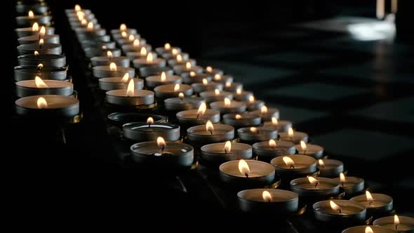 Rows of Burning Lit Candles in Catholic Cathedral